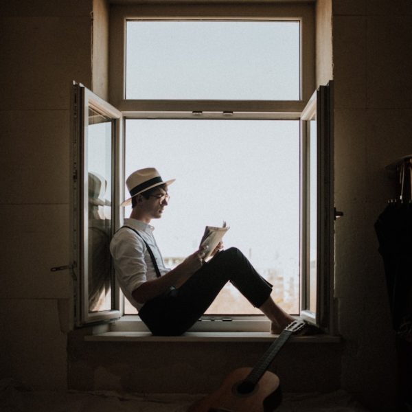 Man Reading Book in Window